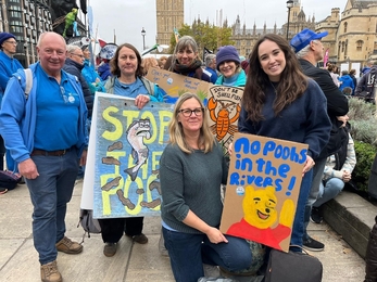 six people posing for a photo with banners relating to the March for clean water protest 