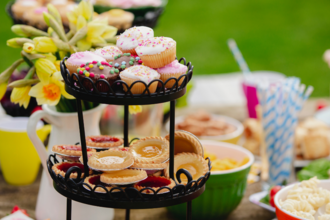 cake on a stand. in the background is a jug full of daffodils and various other nibbles 