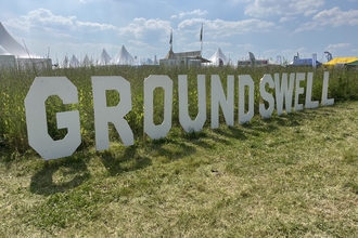 Big white letters spelling out 'Groundswell' in green grass field