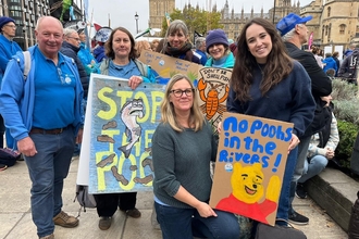 six people posing for a photo with banners relating to the March for clean water protest 