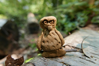 Clay owl sitting on a log made at Swanwick Lakes Wildlife Rangers