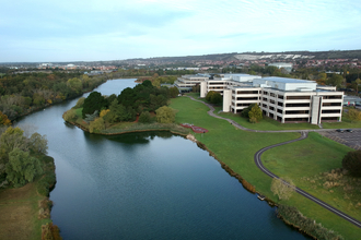 an aerial image of a large building next to a body of water