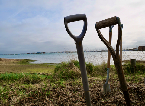 three shovel handles to the right in foreground, in background is shore and water surrounding milton locks