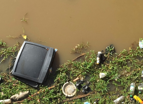 polluted water way with rubbish floating